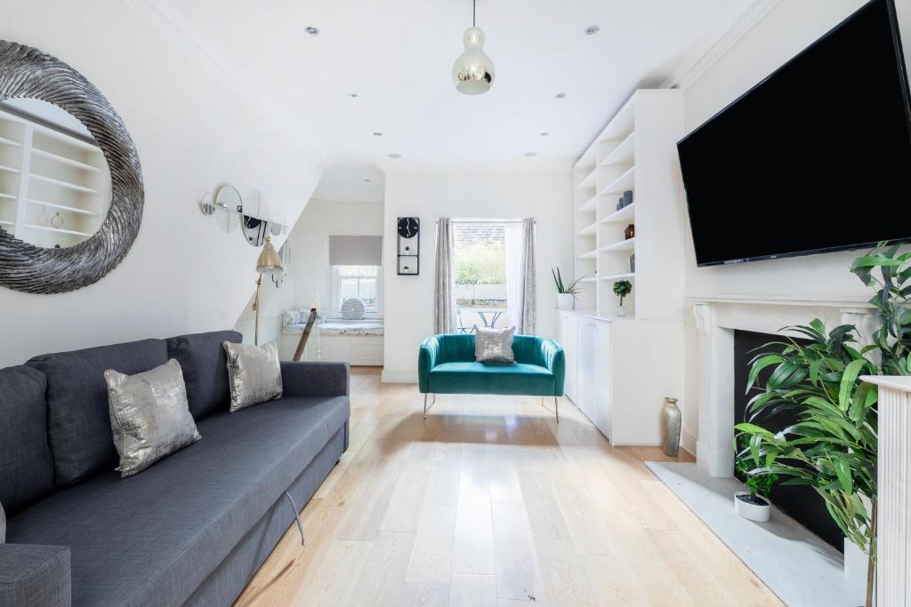 a living room with a couch and a flat screen tv at Beautiful 4 Bedroom House near Paddington Station in London