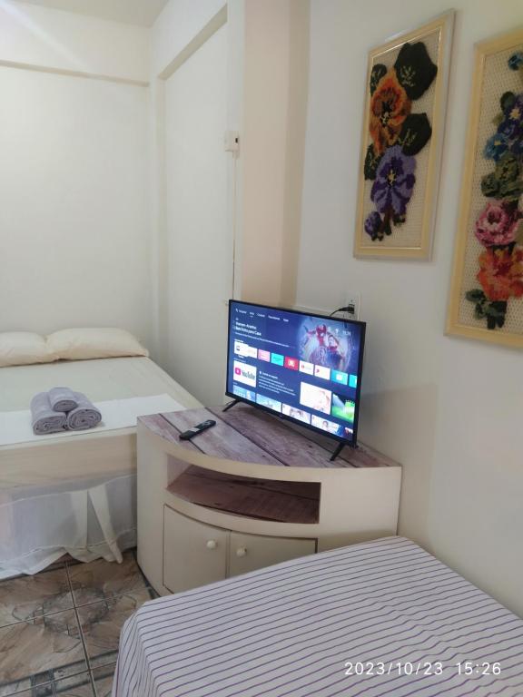 a bedroom with a desk with a computer on it at Kitnet Rústica Blumenau in Blumenau