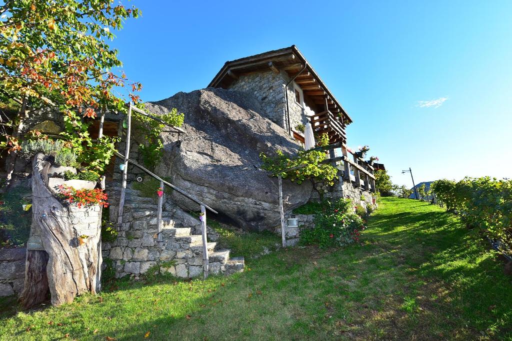 ein altes Steinhaus mit Treppen neben einem Felsen in der Unterkunft RUSTICO VIGNA casa vacanze in Civo