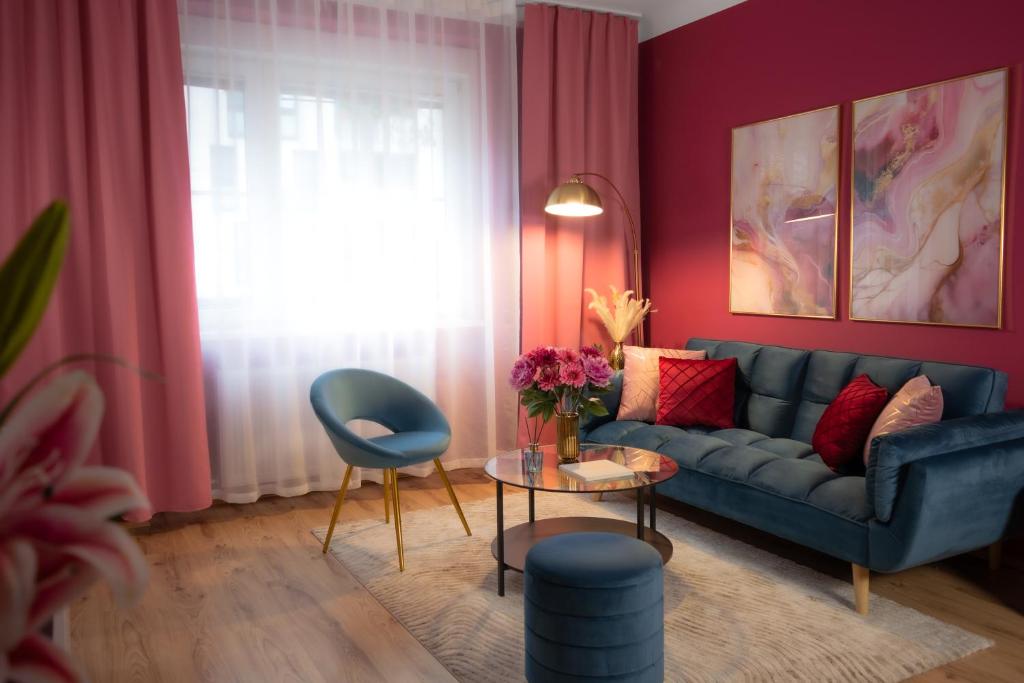 a living room with a blue couch and a table at Designer Luxury Apartment near Prater in Vienna