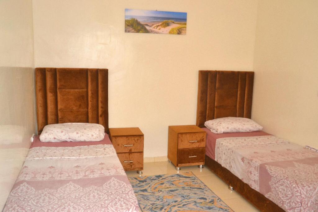 sypialnia z 2 łóżkami i dywanem w obiekcie Apartment am Meer mit Pool w mieście Aurir