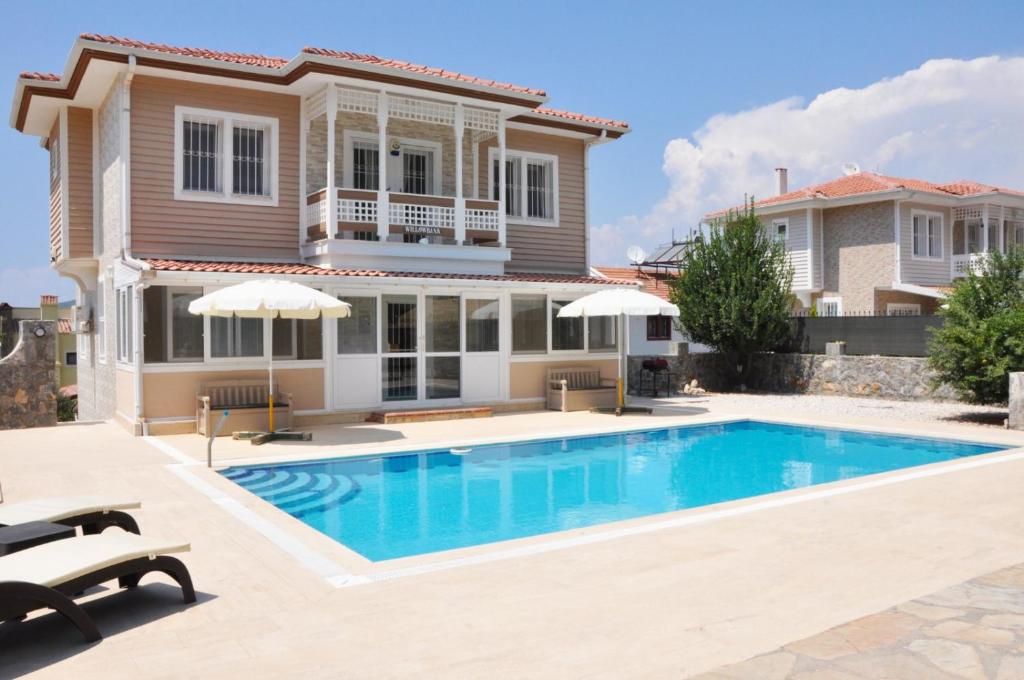 a villa with a swimming pool in front of a house at Villa Steve in Fethiye