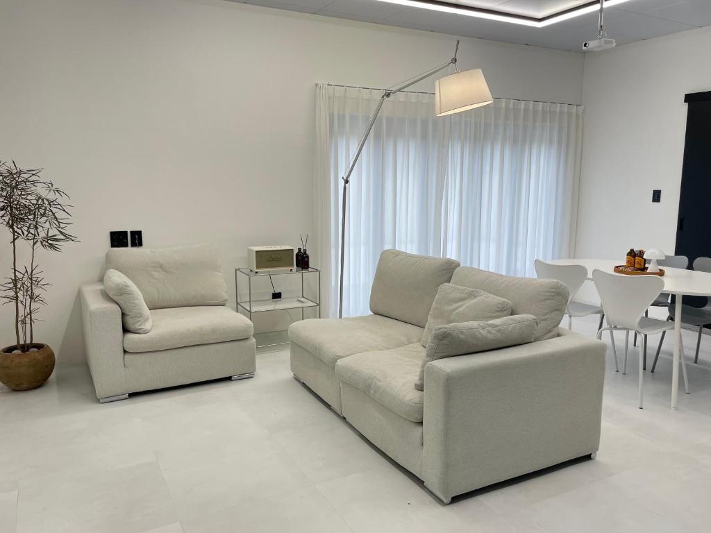 2 sillas y un sofá en la sala de estar en 신규오픈, 프라이빗 독채 풀빌라 펜션, 스테이티모가, en Muju