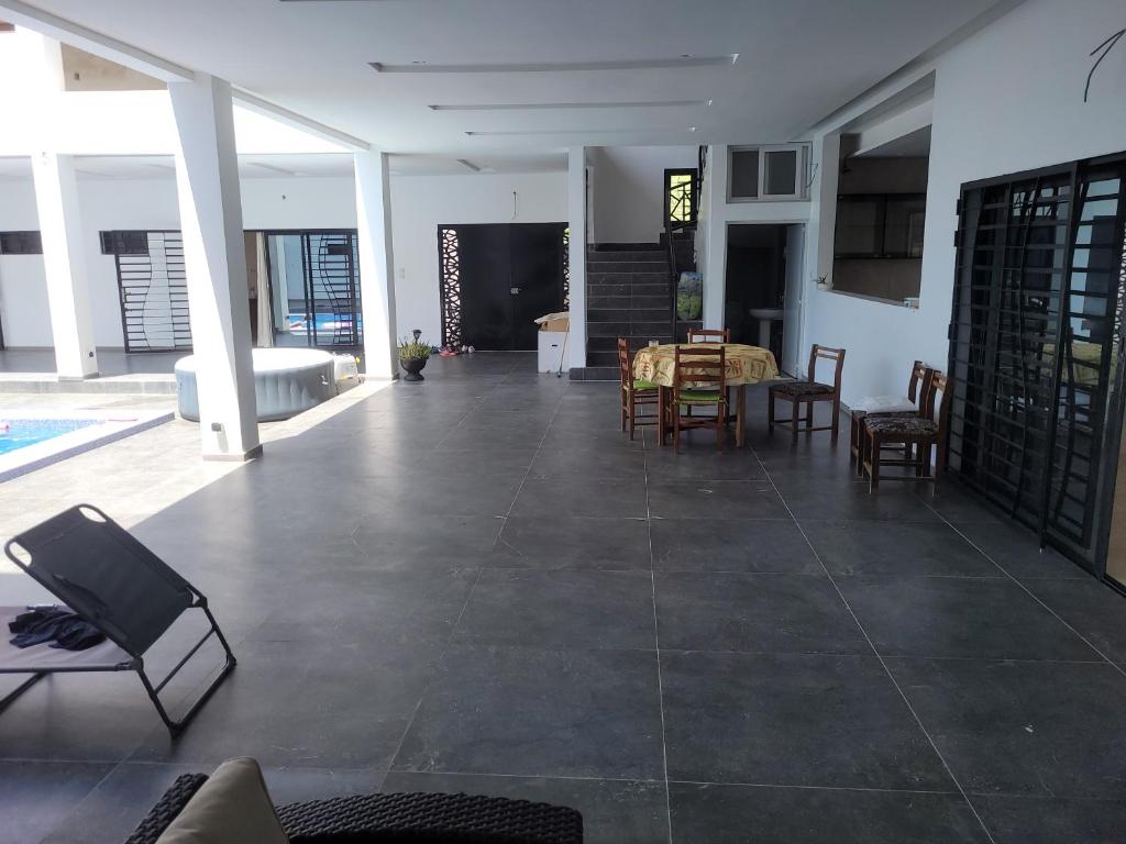 Villa Sylla fall في توباب ديالاو: غرفة معيشة كبيرة مع طاولة وكراسي