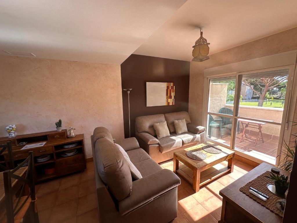 a living room with a couch and a table at En la zona más tranquila del Novo Sancti Petri in Chiclana de la Frontera