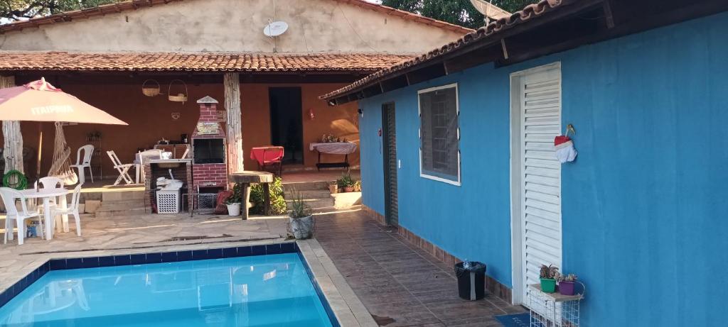 een blauw huis met een zwembad en een patio bij Aconchego Santa Luzia in Pirenópolis
