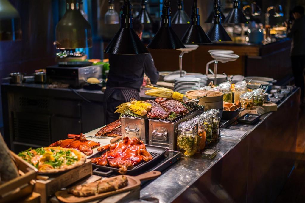A buffet counter displaying hot dishes, seafood and prepared accompaniments.
