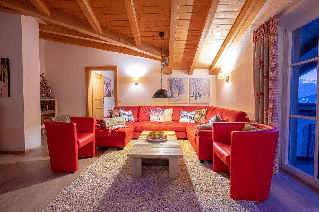 uma sala de estar com sofás vermelhos e uma mesa em All Seasons Lodge by All in One Apartments em Kaprun