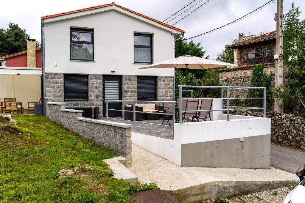 a house with an outdoor patio with an umbrella at Apartamentos Baldenora in Llanes