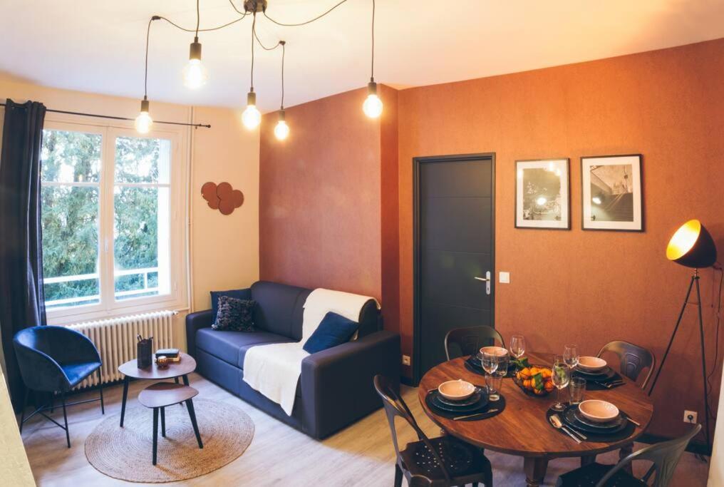 uma sala de estar com um sofá e uma mesa em Charmant appartement - Chambre séparée - 300m de la gare et accès direct au cœur historique em Poitiers
