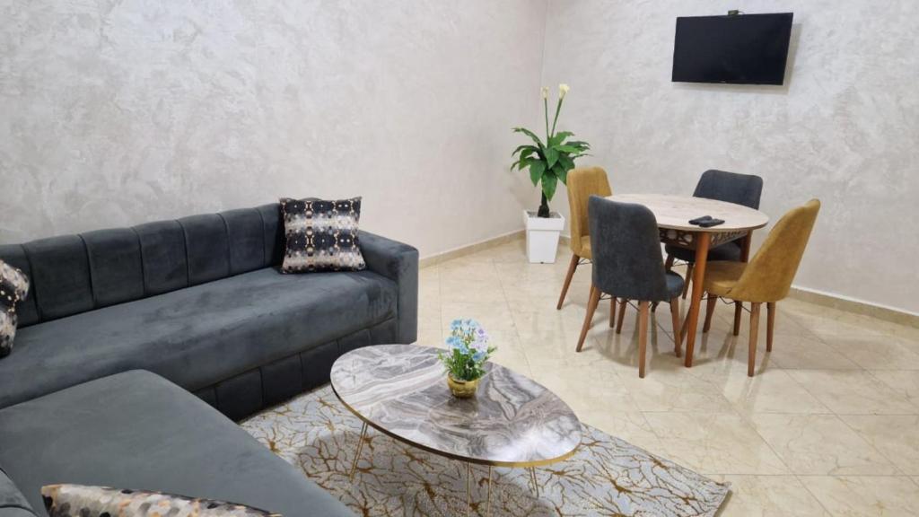 uma sala de estar com um sofá e uma mesa em Elégant appartement Chez Yalah em Temara
