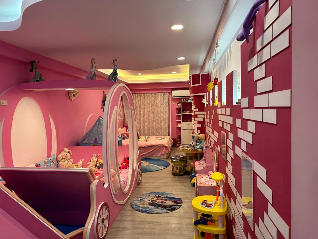 Dormitorio infantil con paredes rosas y espejo en Kenting Mola, en Nanwan