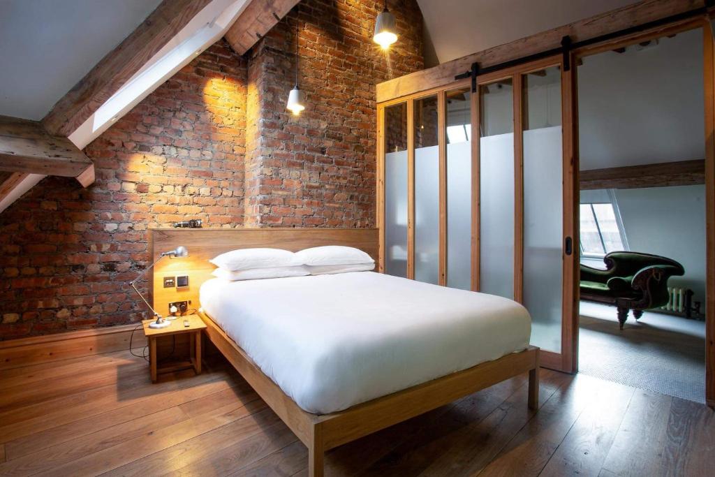 sypialnia z łóżkiem i ceglaną ścianą w obiekcie O'Regans w Dublinie