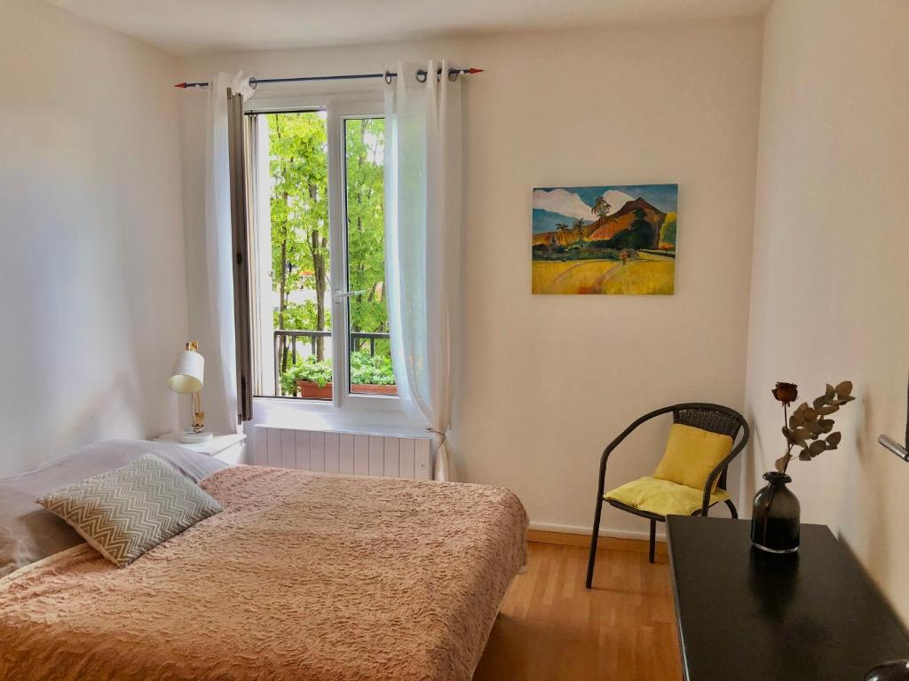 1 dormitorio con cama y ventana en Le Fontenay bleu, en Bourg-la-Reine