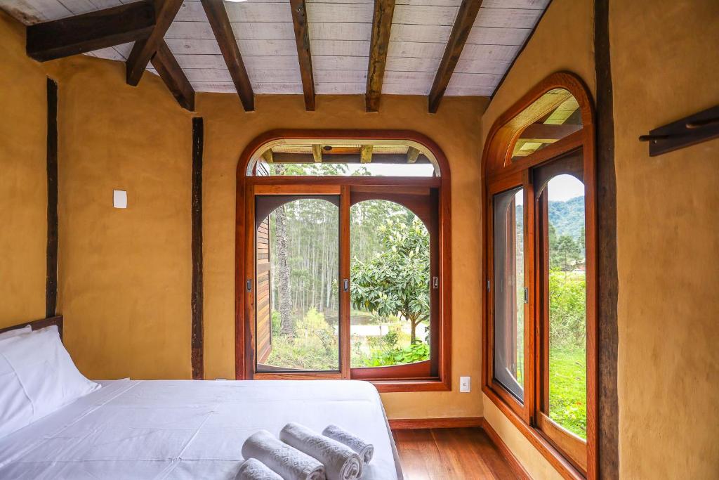 a bedroom with a bed and a window at Pousada Rural Ritmos da Terra in Angelina