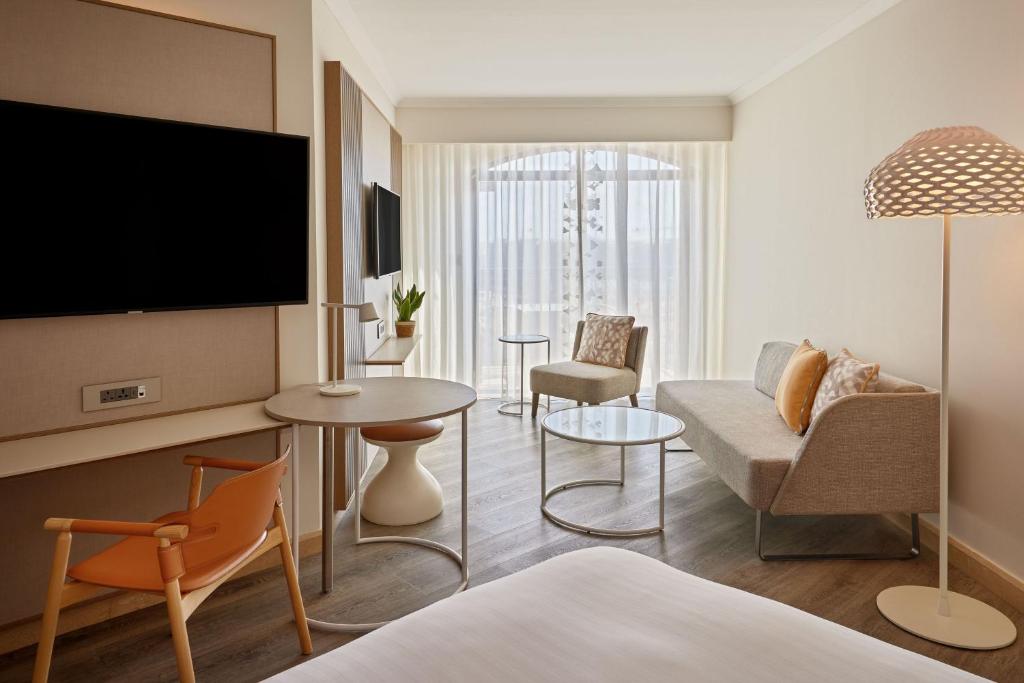 a living room with a couch and a table at Malta Marriott Resort & Spa in St. Julianʼs