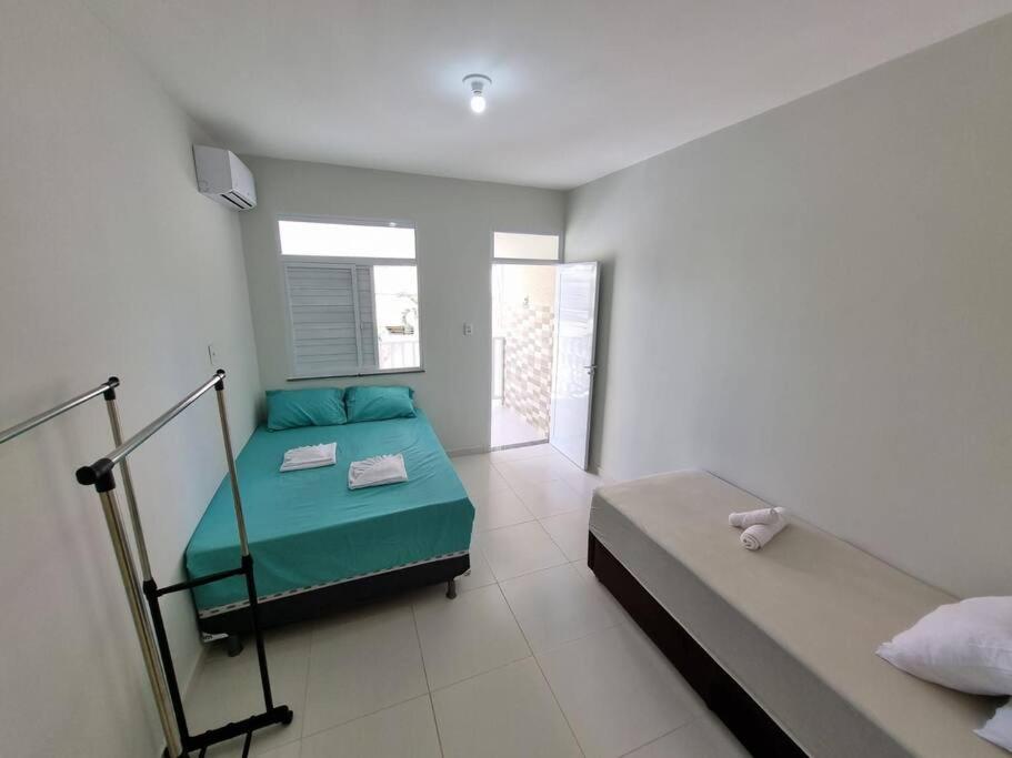 1 dormitorio con 2 camas y ventana en Casa 2/4 para temporada en Aracaju