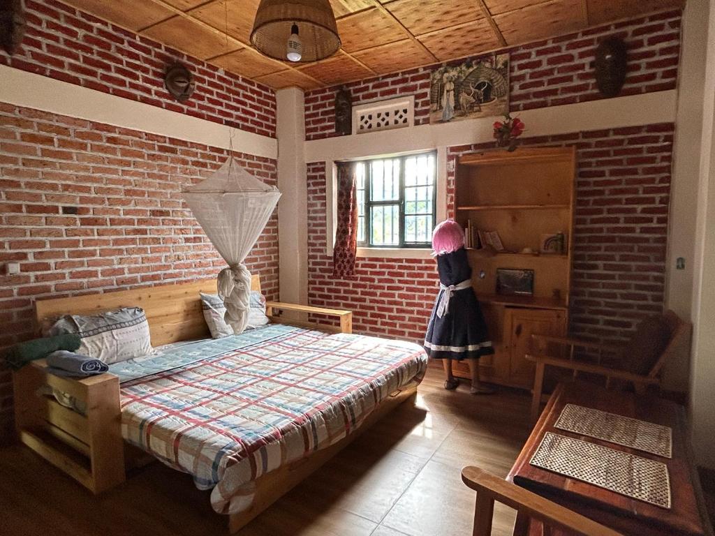 una camera con un letto in un muro di mattoni di Stany's apartments a Butare