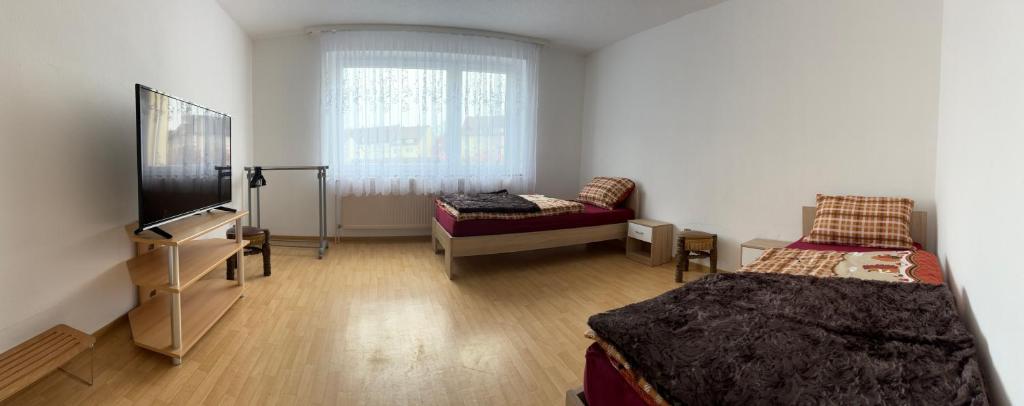 プフォルツハイムにあるFerienwohnung Grimmのベッド2台、テレビ、ソファが備わる客室です。