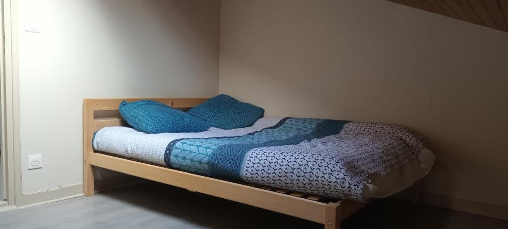 Un dormitorio con una cama con almohadas azules. en Balzac en Montfort-sur-Meu