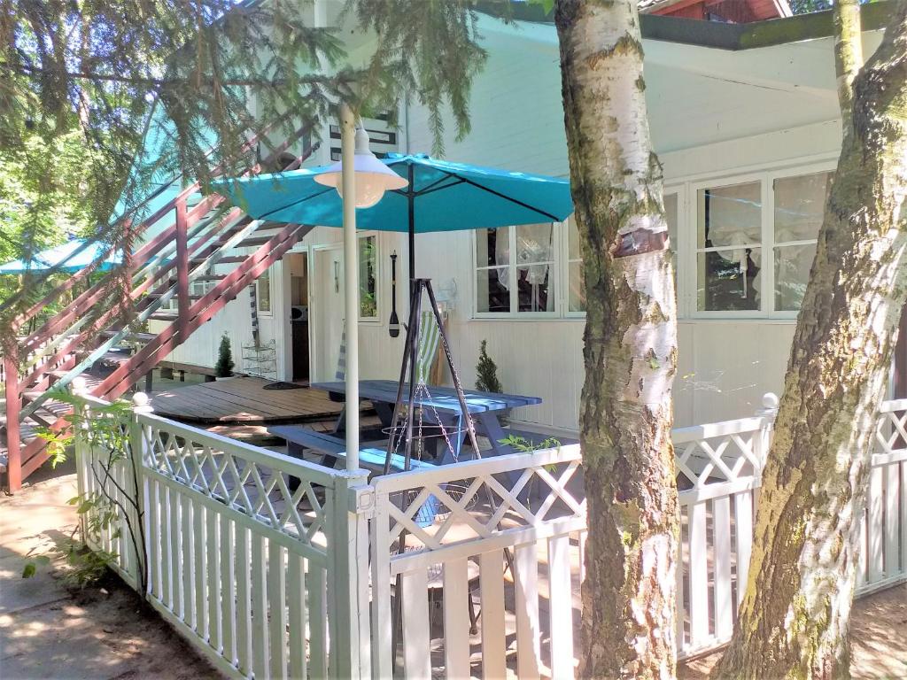 a house with a table and an umbrella at Fajna Chatka (mieszkanko B) in Stegna