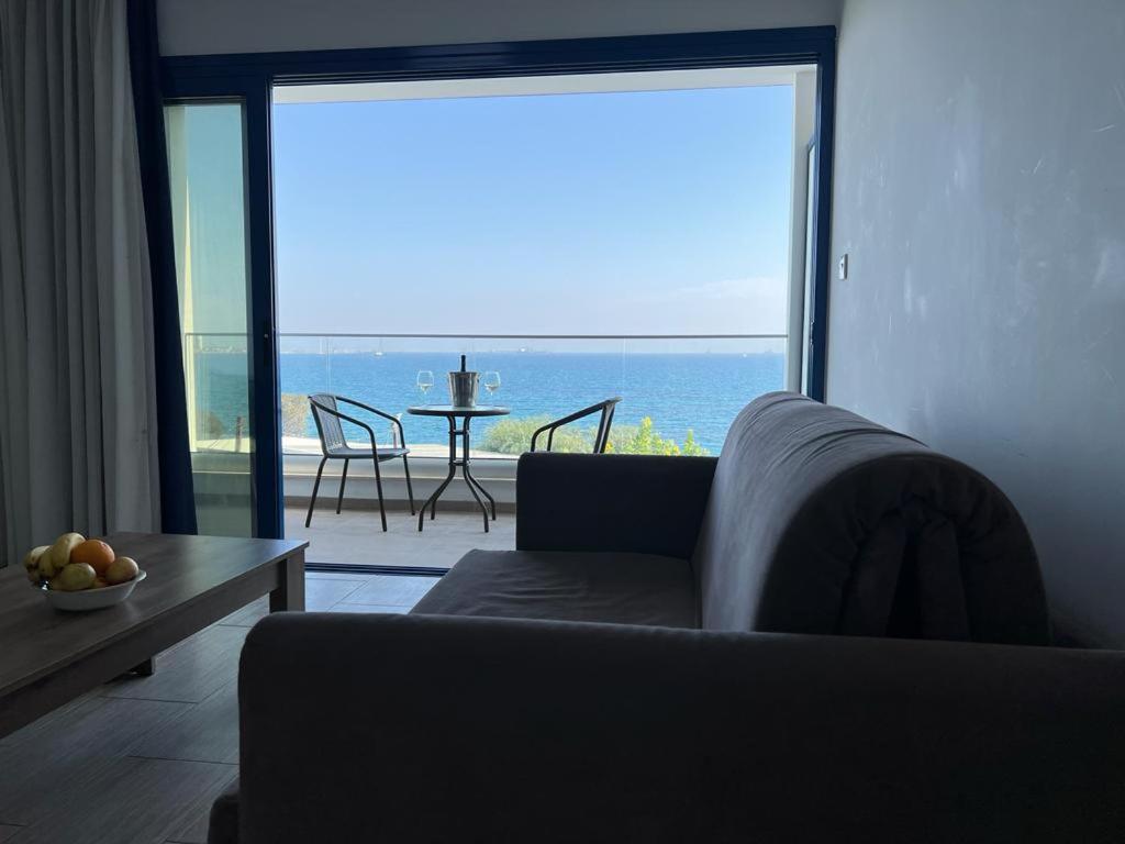 uma sala de estar com um sofá e vista para o oceano em Governors Beach Panayiotis em Governors Beach