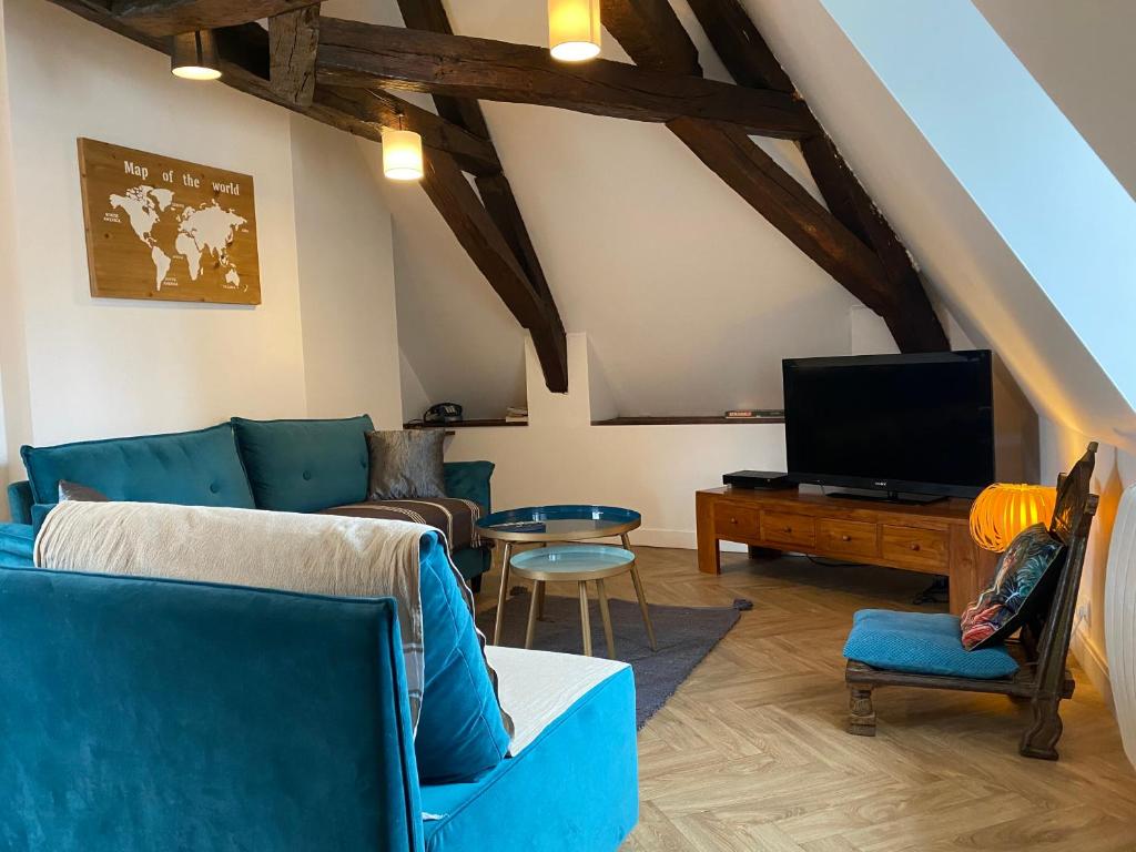 un salon avec un canapé bleu et une télévision dans l'établissement Le KT-Dral - Appartement hypercentre, à Bourges