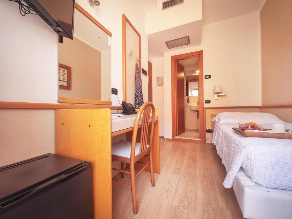 a bedroom with a bed and a desk with a sink at Hotel Florida Lerici in Lerici