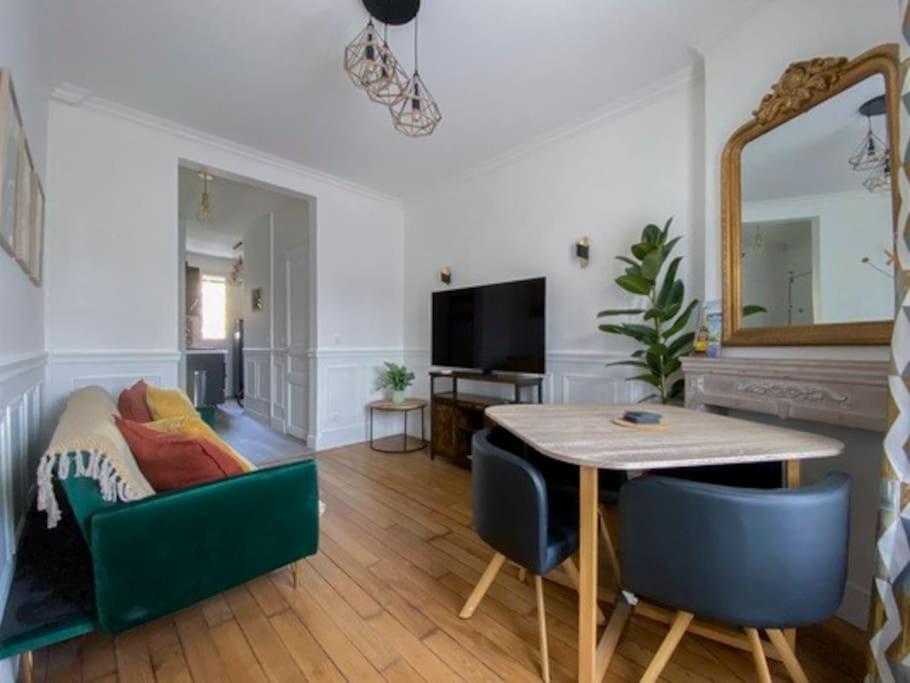 sala de estar con mesa, sillas y espejo en Parisien style T2 in center of Puteaux, en Puteaux
