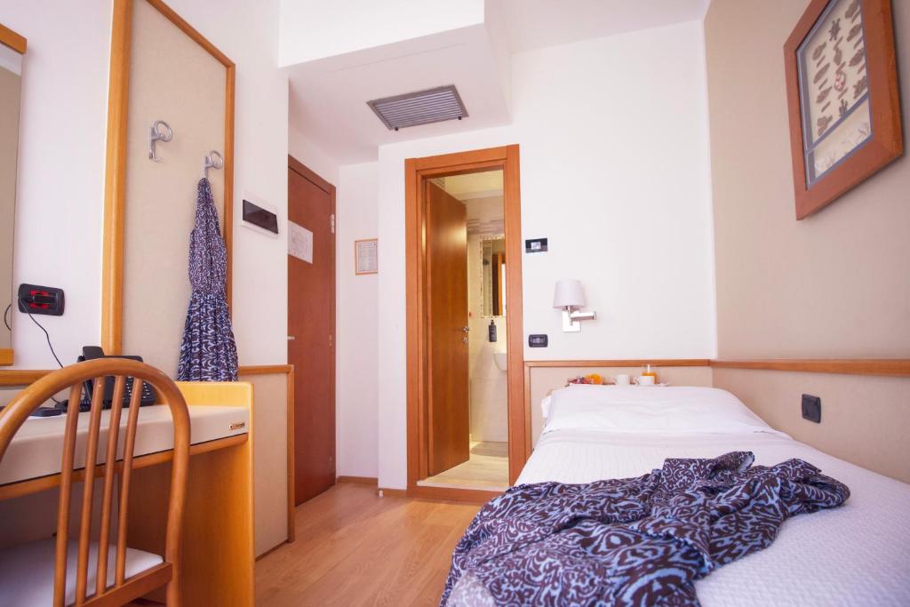 a bedroom with a bed and a desk and a mirror at Hotel Florida Lerici in Lerici