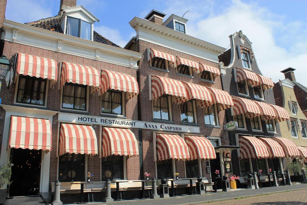 a building with red and white awnings on it at Hotel Anna Casparii in Harlingen
