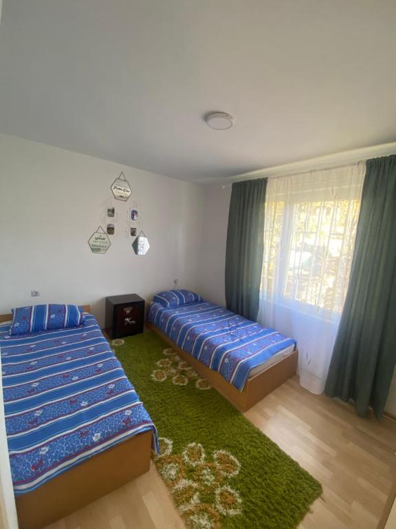 Un dormitorio con una cama azul y una alfombra verde en Apartman Bilanovic, en Konjic