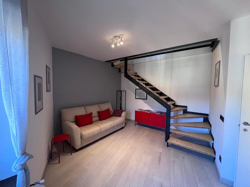 ein Wohnzimmer mit einem Sofa und einer Treppe in der Unterkunft La Zinevra in Rovereto