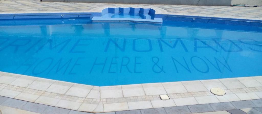 a swimming pool with a sign that reads make memories have here and now at Prime Nomads in Kisumu