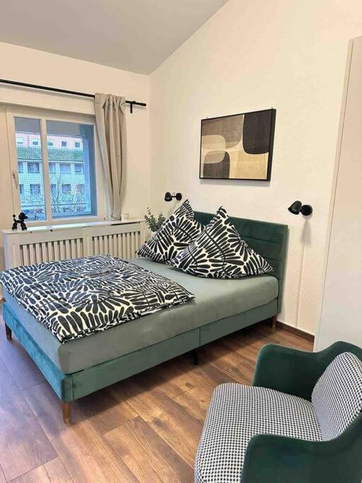 a bedroom with a bed and a couch and a window at Wohnen im Grünen in Karlsruhe
