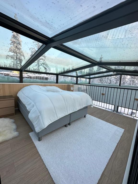 Schlafzimmer mit einem Bett vor einem großen Fenster in der Unterkunft Levi Aurora Sky in Levi