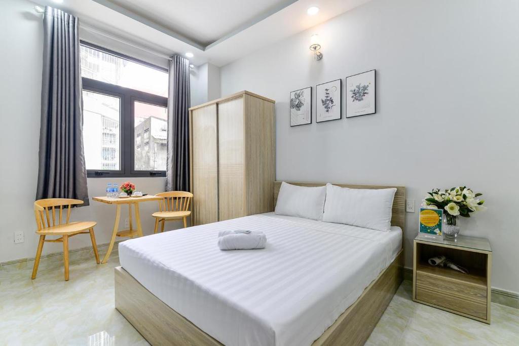 Cái Răng的住宿－Iris Hotel，卧室配有白色的床和桌子