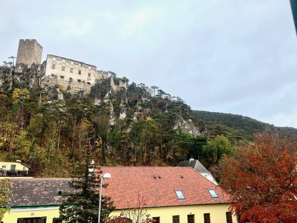a castle on the side of a mountain with houses at Stilvolles Studio- Apartment mit einzigartiger Aussicht in Baden