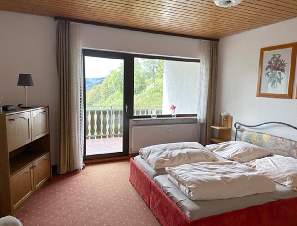 a bedroom with a bed and a large window at Schwarzwaldblick in Triberg