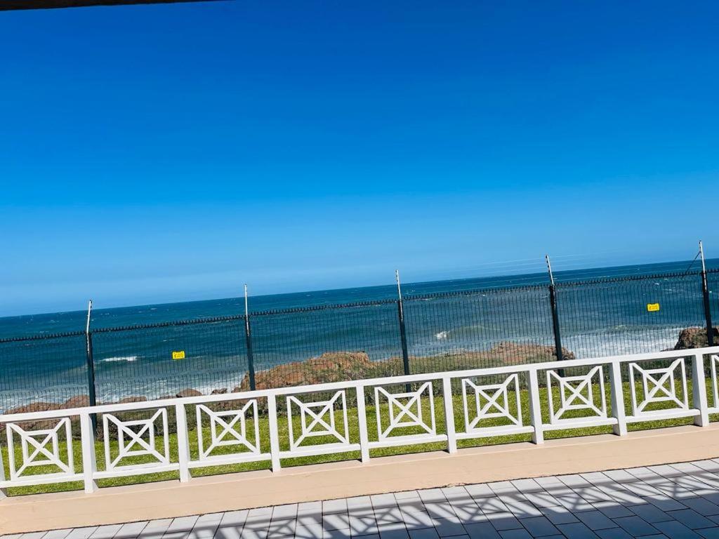 a white fence with the beach in the background at Ramsgate Beach house in Margate