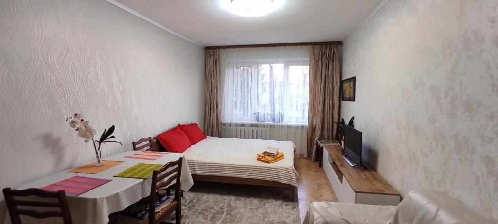 ein kleines Zimmer mit einem Bett und einem Fernseher in der Unterkunft Двухкомнатная квартира на Арбате in Almaty