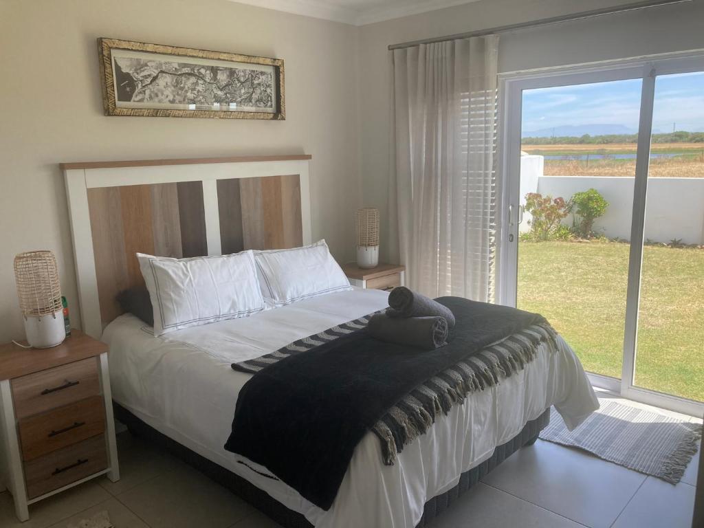 ein Schlafzimmer mit einem großen Bett und einem großen Fenster in der Unterkunft Blessed at Ten76 holiday home in Witsand in Witsand