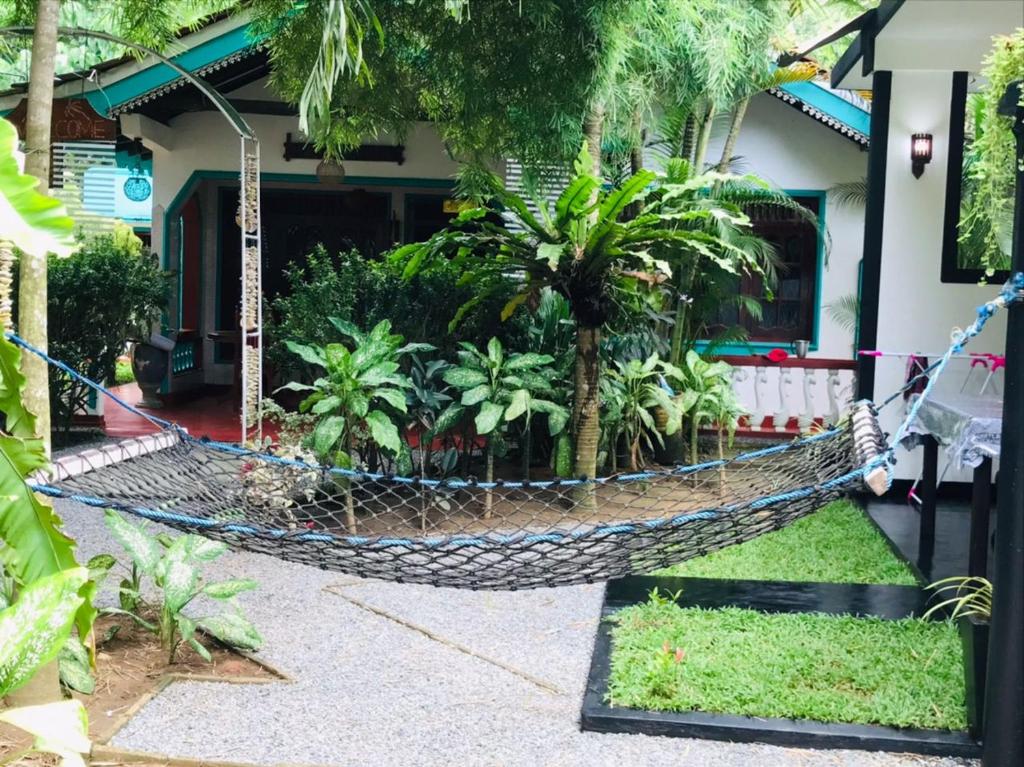 a hammock in front of a house with palm trees at Unakuruwa silent beach villa in Tangalle