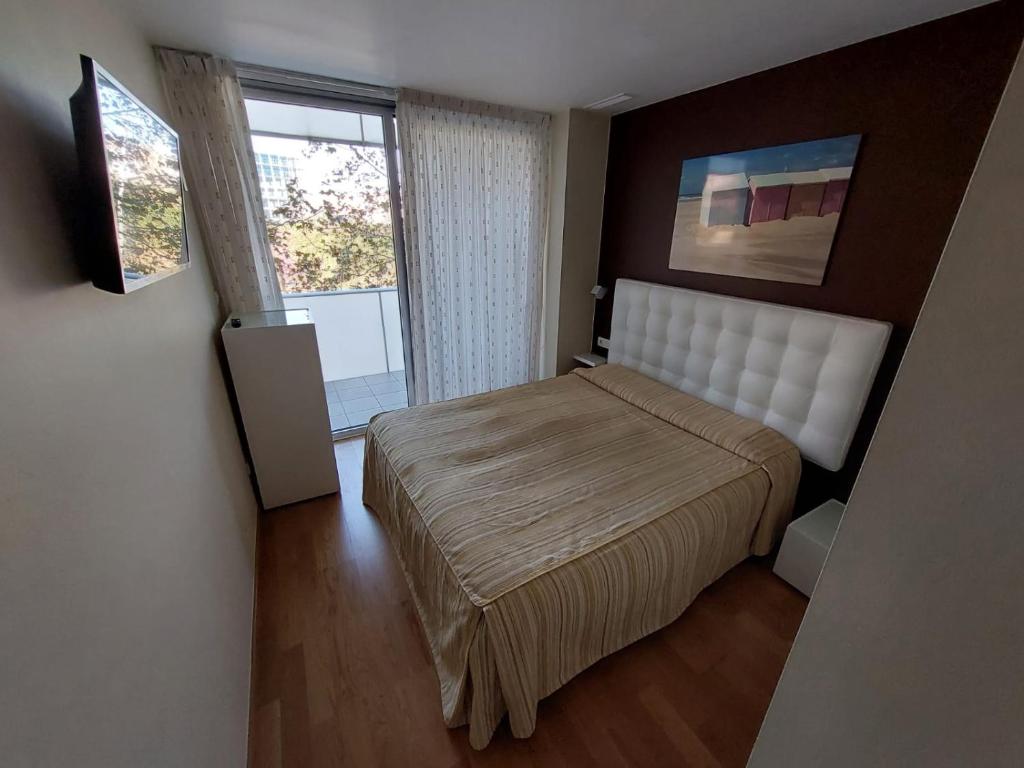 um pequeno quarto com uma cama e uma janela em Angeles Terraza em Barcelona