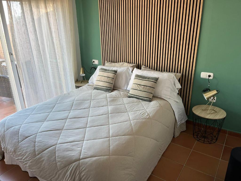 a bedroom with a large white bed with a wooden headboard at Apto. Residencial La Alcaidesa in Alcaidesa