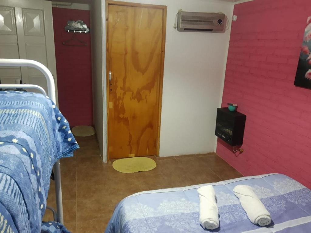 Cette chambre comprend un lit et une porte en bois. dans l'établissement dormi La familia, à Malargüe