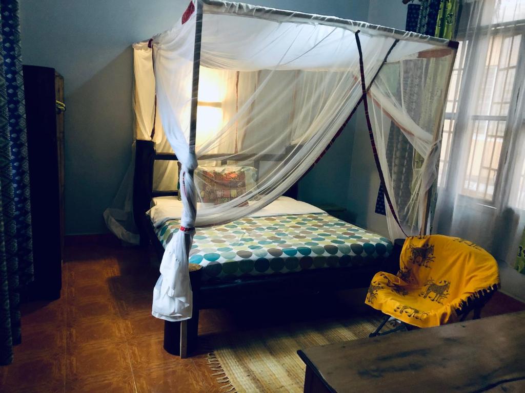 a bed with a canopy in a room at The apartment house in Mbale
