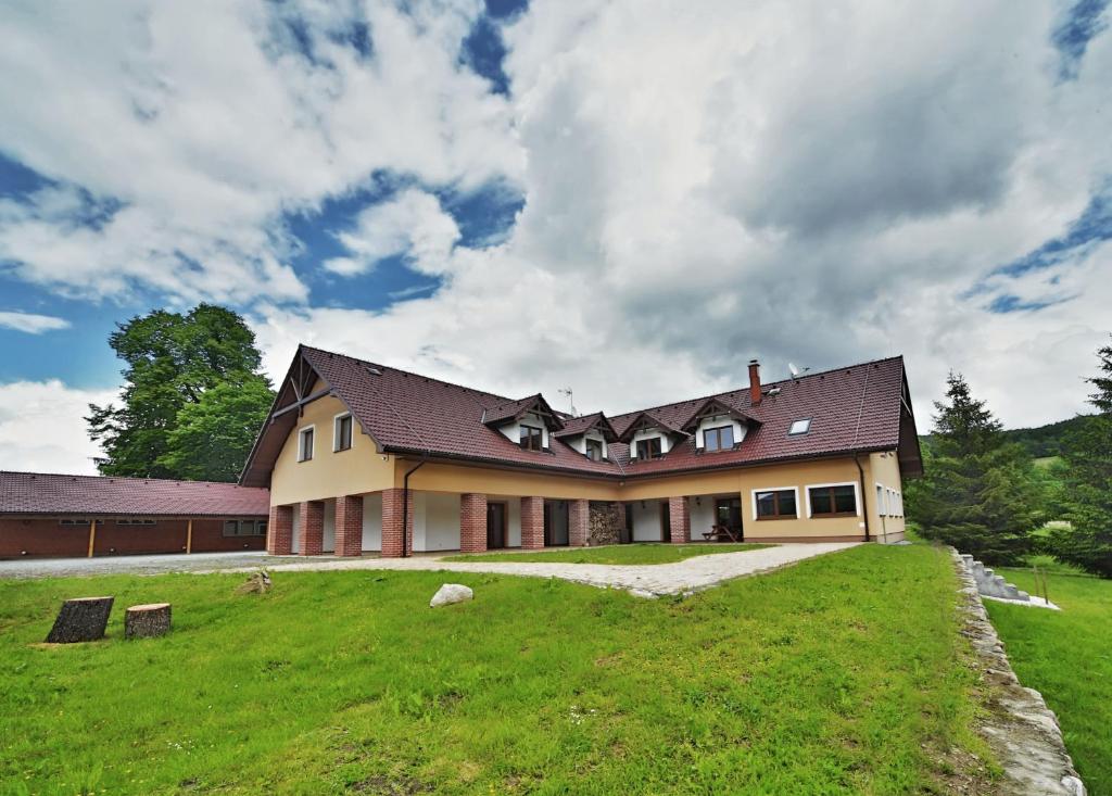 a large house on a hill with a green yard at Penzion Šejby in Horní Stropnice