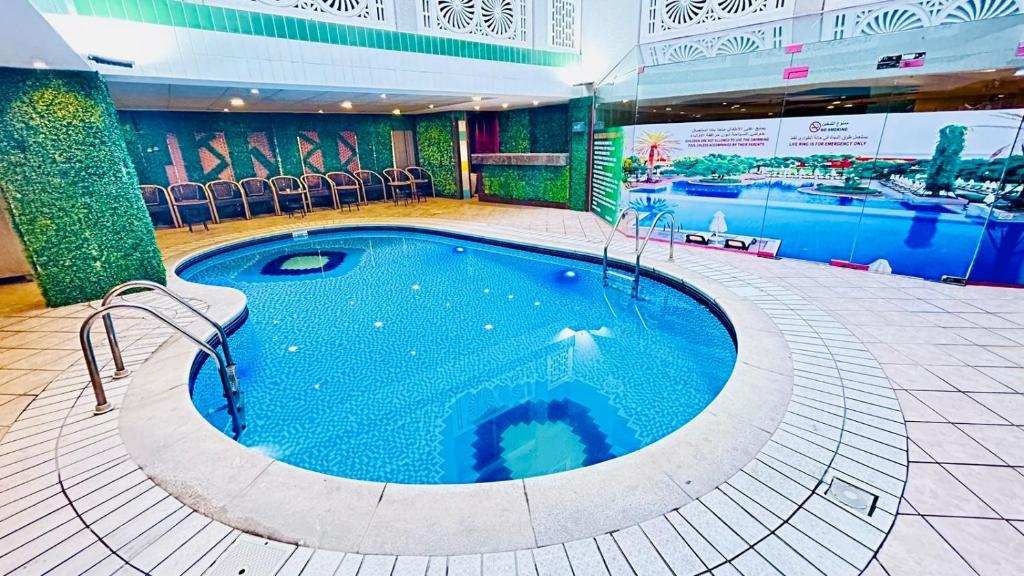 a large swimming pool in a hotel room at Queens Hotel in Dubai