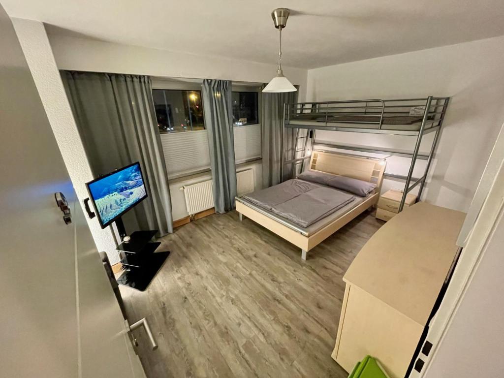 a small bedroom with a bunk bed and a television at WinWin im Westen in Bielefeld